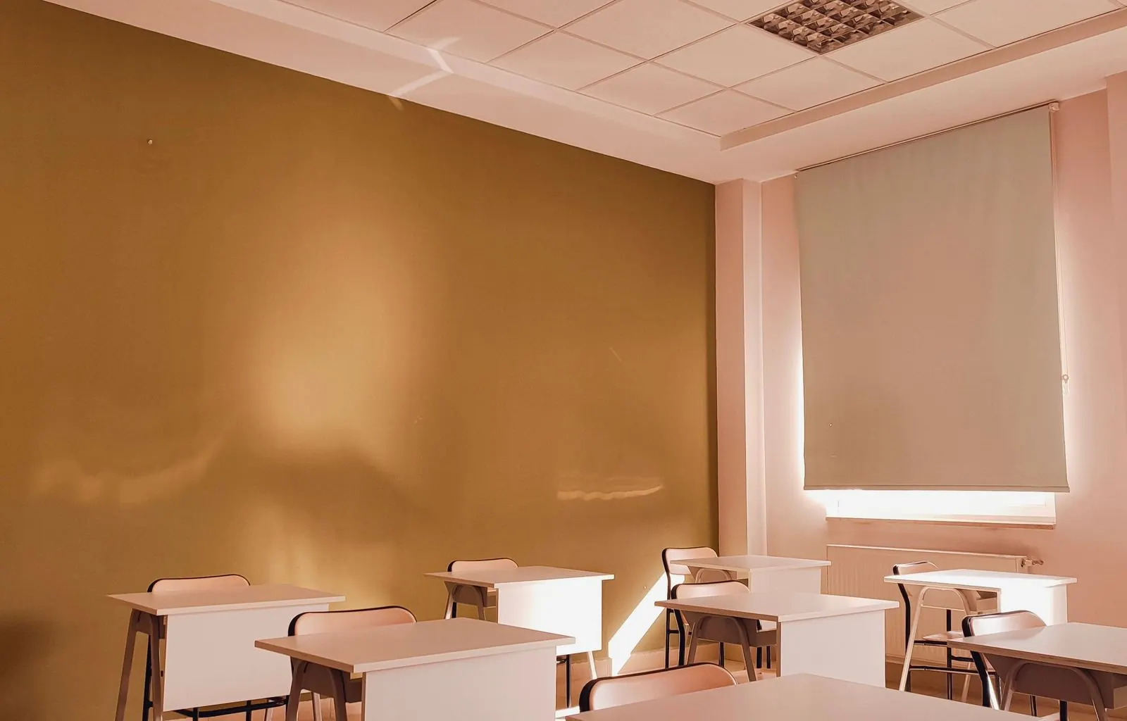 Bright cleaned elementary classroom with mopped tile floor and organized desks